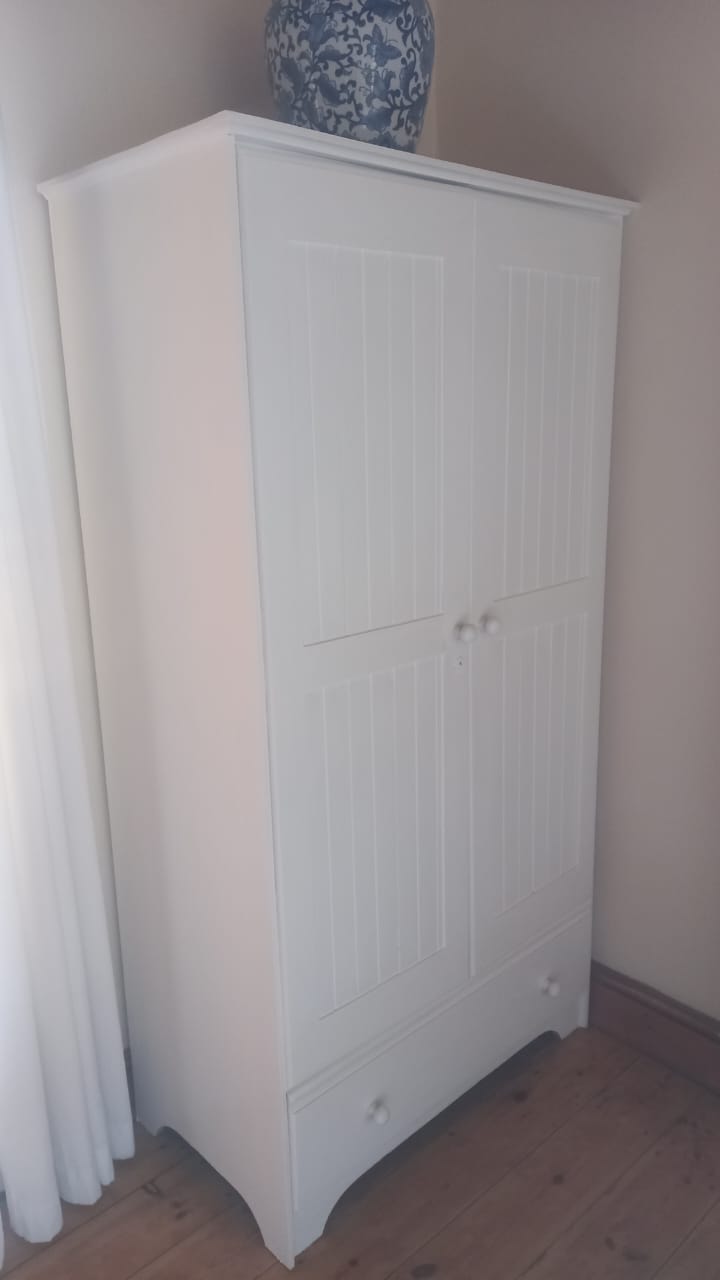 Completed armoire with bottom drawer storage and decorative vase accent